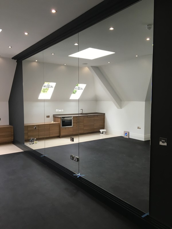 Frameless glass partition in loft conversion by Kensington glaziers